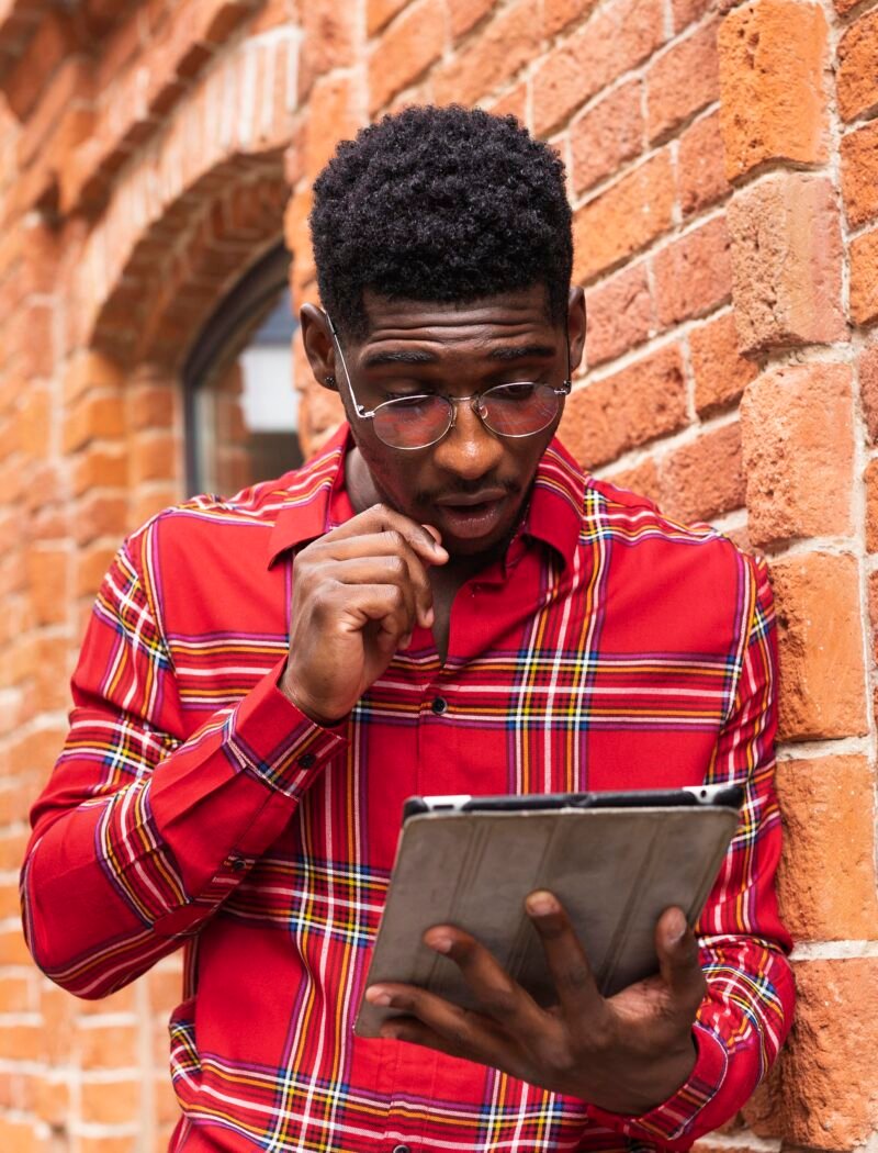 man-wearing-glasses-reading-from-his-digital-tablet