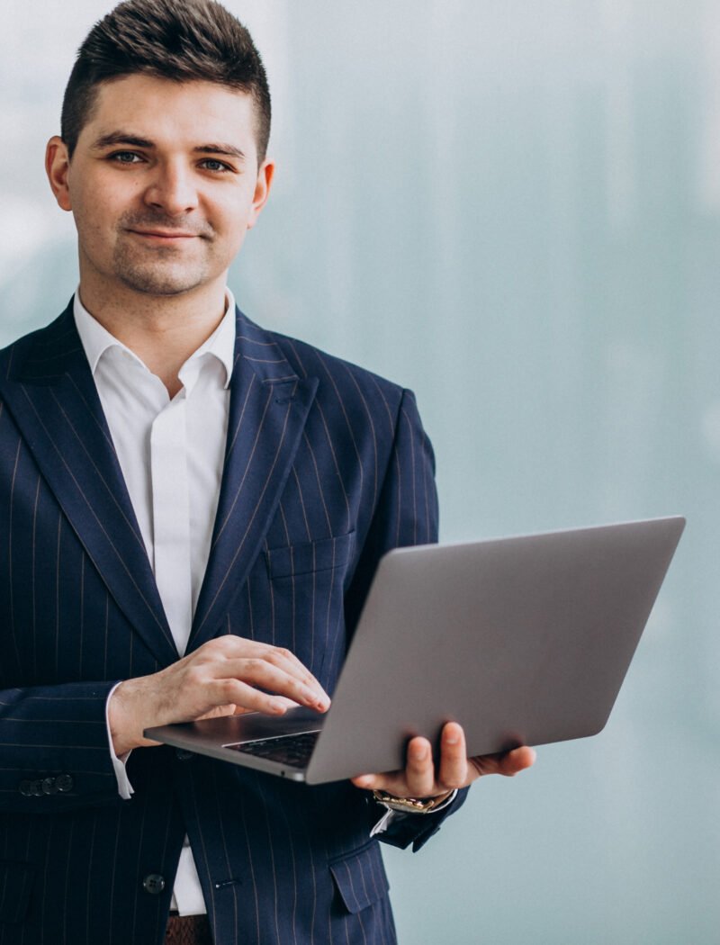 Young handsome business man with laptop in office